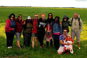 Group of Explore students posing in a canola field on a sunny day